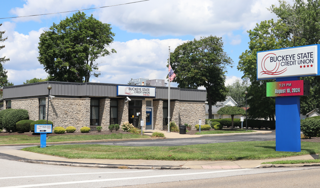 BSCU Hartville Branch: Credit union building with digital sign, surrounded by greenery.